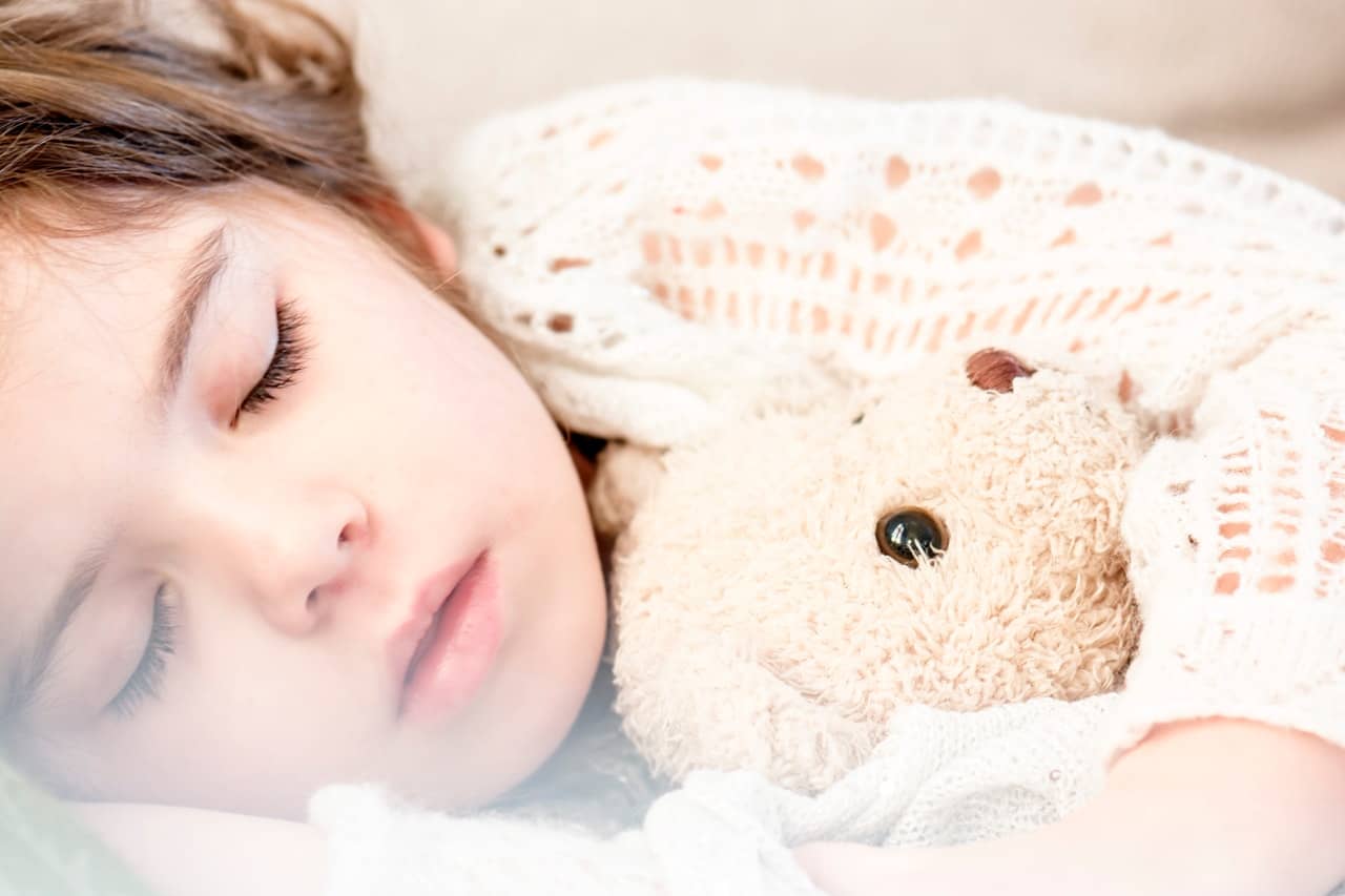 girl-sleeping-with-her-brown-plush-toy-101523